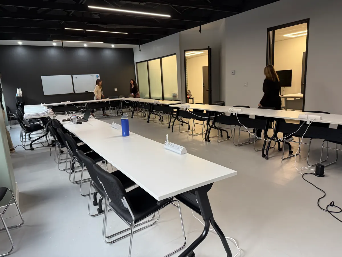 Training tables set in a U for a board meeting, whiteboards on the wall.
